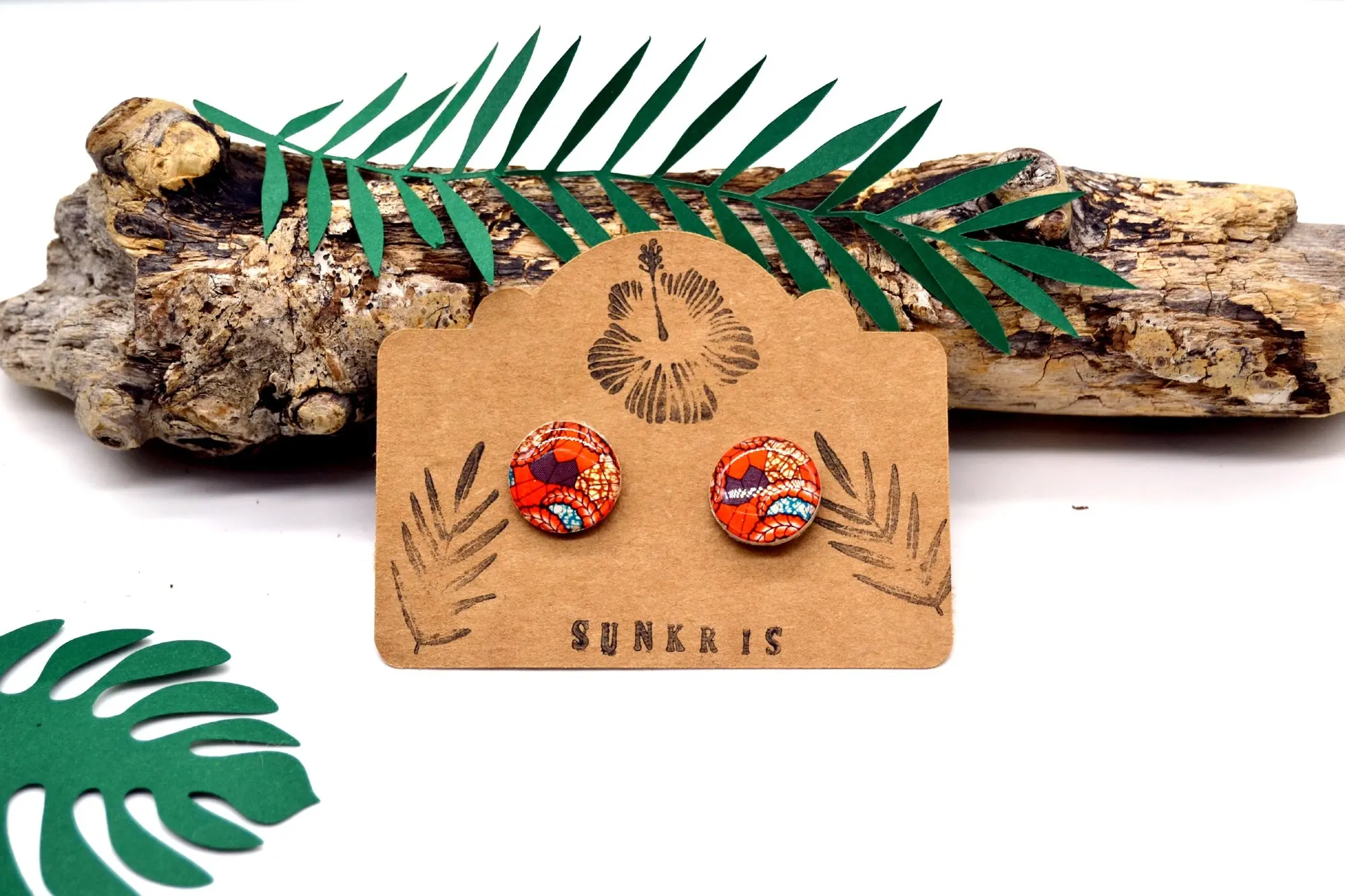 Small round wooden earrings and blue orange colored wax paper