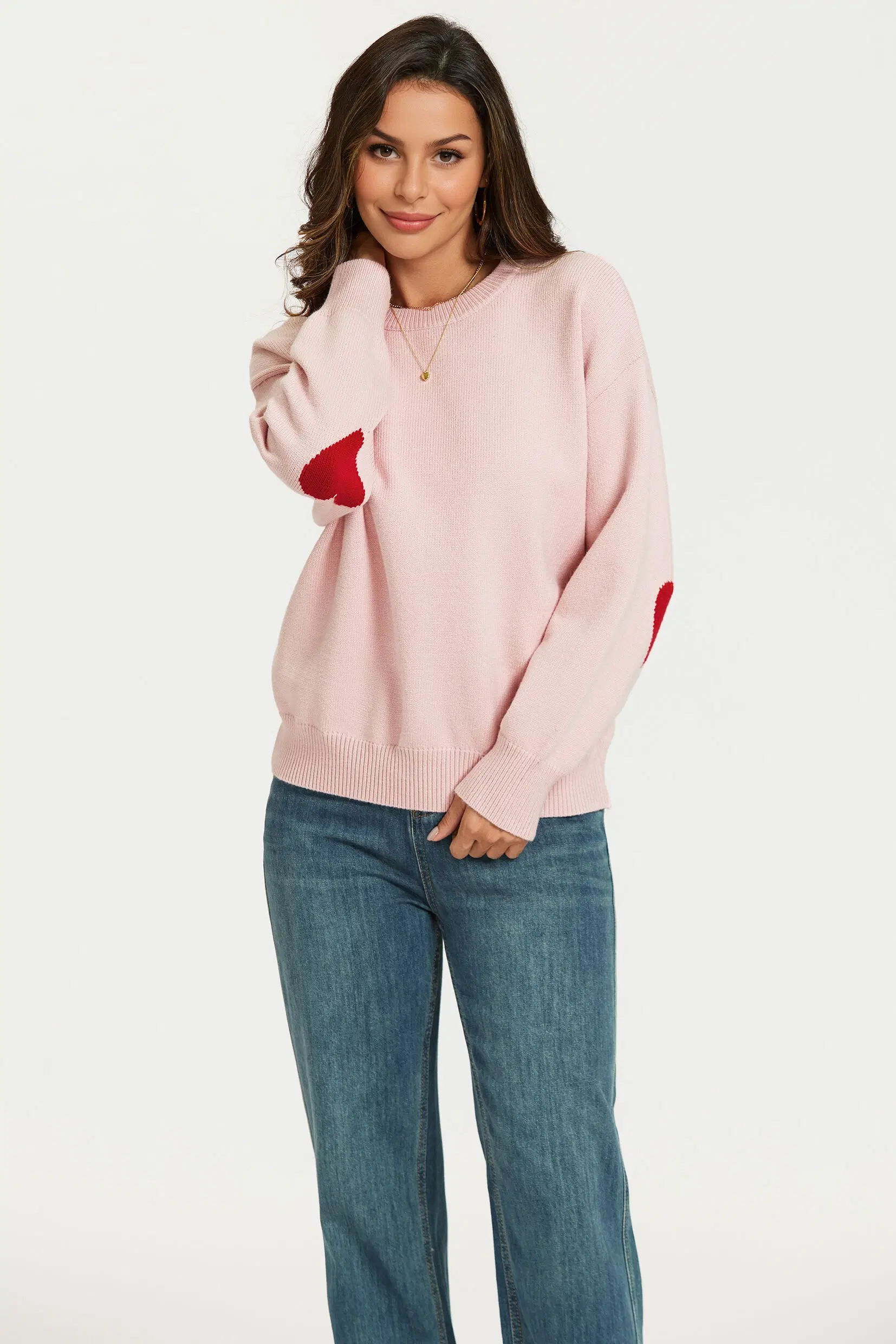 Pink knitted sweater with a red heart pattern on the sleeves
