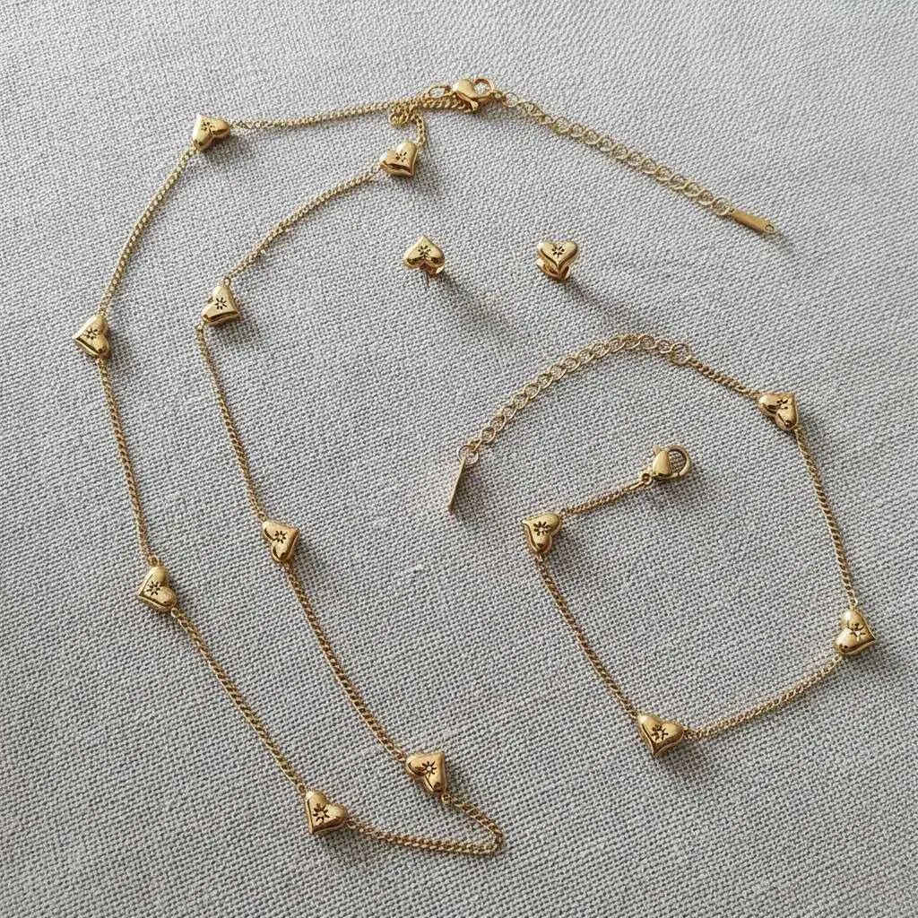 Jewelry set: heart-shaped beaded choker with star-shaped cubic zirconia and matching bracelet and earrings in 18K gold-plated PVD waterproof stainless steel.